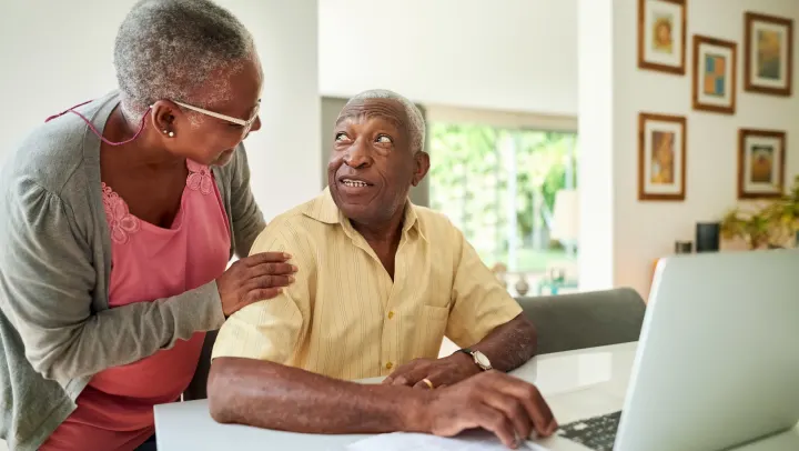 elderly couple in front of laptop
