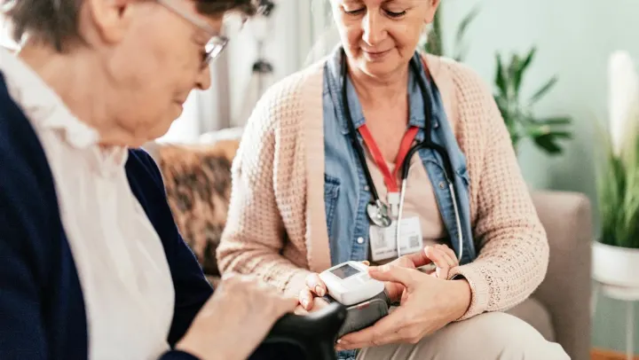 nurse assisting elderly woman